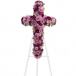 Purple floral cross on a white stand