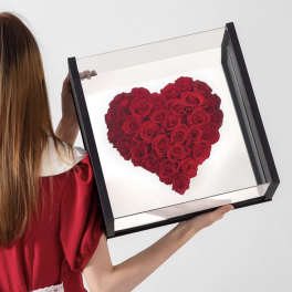 Heart-shaped arrangement of red roses in a black display box