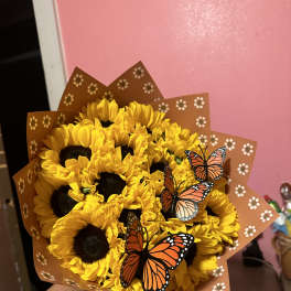 Bouquet of yellow sunflowers wrapped in brown paper with butterfly decorations