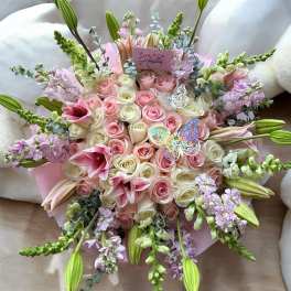 Round bouquet of pink and white roses with lilies and lavender flowers