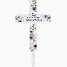 Decorative memorial cross with purple flowers and a stake