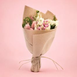 Bouquet of pink and white flowers wrapped in brown paper