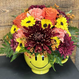 Mixed bouquet in a yellow smiley-face mug