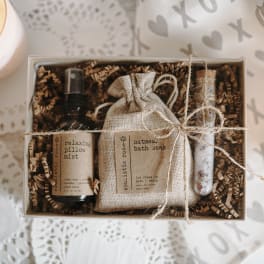 Gift box with a pillow mist bottle, bath soak pouch, and a small vial