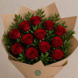Bouquet of red roses wrapped in brown paper with a raffia bow