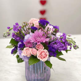 Pink and purple mixed bouquet in a ribbed glass vase