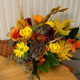 Autumn bouquet with yellow and orange flowers in a wicker cone