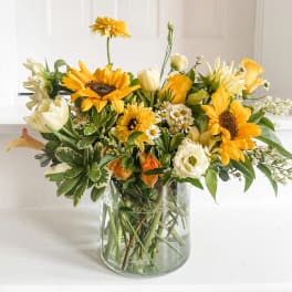 Yellow and white mixed bouquet in a clear glass vase