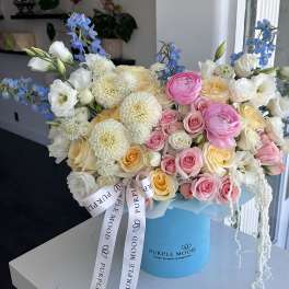 Bouquet of pink, white, and cream flowers in a blue hat box