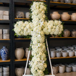 White floral cross on a white stand