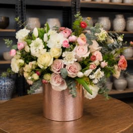 Mixed bouquet of pink, white, and cream flowers in a copper vase