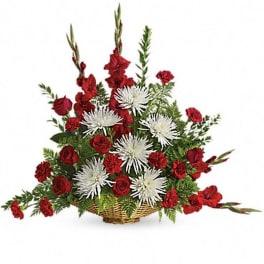 Red and white floral arrangement in a wicker basket