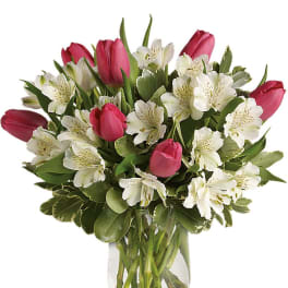 Pink tulips and white alstroemeria in a clear glass vase
