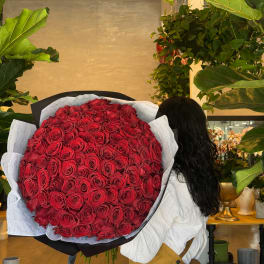 Large bouquet of red roses wrapped in black and white paper