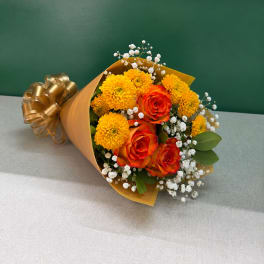 Bouquet of orange roses and yellow chrysanthemums wrapped in gold paper