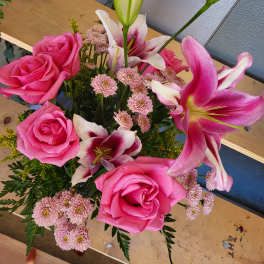 Pink roses and lilies with small pink daisies in a bouquet