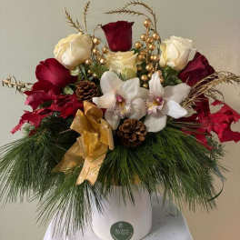 Holiday arrangement with red and white roses in a white vase