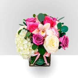 Pink and white roses with hydrangea in a square glass vase