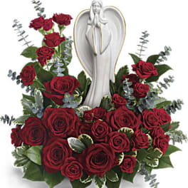 Red rose arrangement with a white angel statue centerpiece