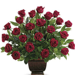 Red roses arranged in a dark urn vase