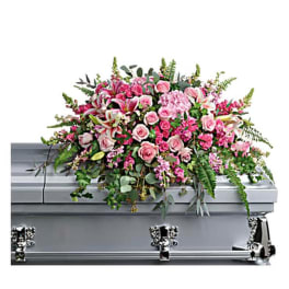 Pink floral casket spray on a silver casket