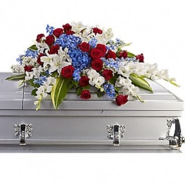 Red, white, and blue floral spray on a silver casket