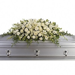White floral casket spray on a silver casket