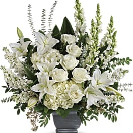 White lilies and roses arranged in a dark vase