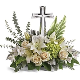 White floral arrangement with a silver cross centerpiece