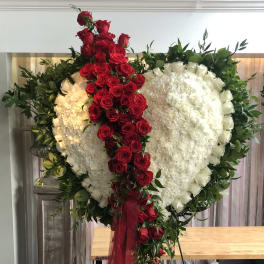 Heart-shaped floral tribute with red roses and white flowers
