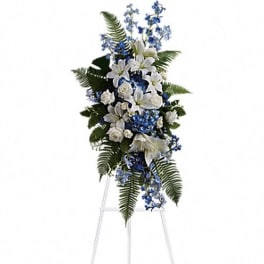 Tall white and blue floral standing spray on an easel