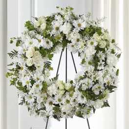 White floral wreath on a black easel stand