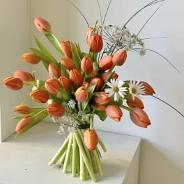 Bouquet of orange tulips with white daisies and airy filler
