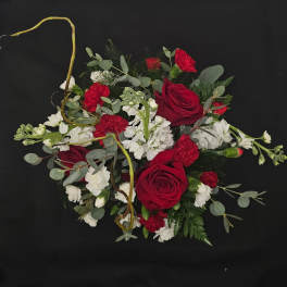Red roses and white carnations arranged with eucalyptus on a black background