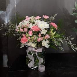 Pink and white mixed bouquet in a glass vase with a ribbon