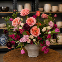 Mixed pink and magenta flowers arranged in a ceramic vase