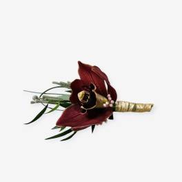 Dark red orchid boutonniere with gold-wrapped stem and greenery