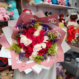 Bouquet of red and white roses wrapped in pink paper