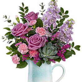 Lavender roses and pink carnations in a pale blue pitcher vase