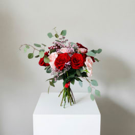 Bouquet of red and pale pink roses with airy filler and eucalyptus