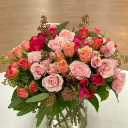Bouquet of pink and coral roses in a clear glass vase