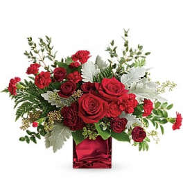 Red rose arrangement in a red glass vase with silver foliage