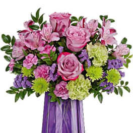 Pink roses and alstroemeria in a purple vase