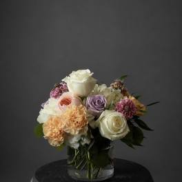 Mixed bouquet of roses and carnations in a clear glass vase