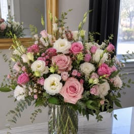 Pink and white roses with white lisianthus in a glass vase