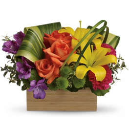 Colorful bouquet with roses and lilies in a wooden box