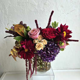 Bouquet of red, purple, and pink flowers in a glass vase
