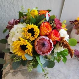 Mixed bouquet with sunflowers, orange roses, and white blooms