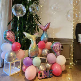 Mermaid-themed balloon display with pastel balloons and clear balloons with lights