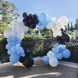 Blue, white, and black balloon arch outdoors